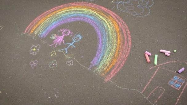 Los niños dibujan con tiza sobre el asfalto. Enfoque selectivo. — Vídeos de Stock