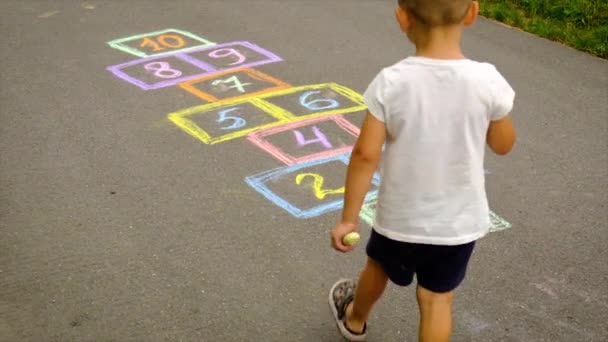 Τα παιδιά παίζουν κλασικά στο δρόμο. Επιλεκτική εστίαση. — Αρχείο Βίντεο