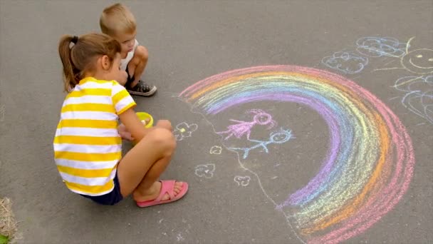 Children draw with chalk on the asphalt. Selective focus. — Stock Video