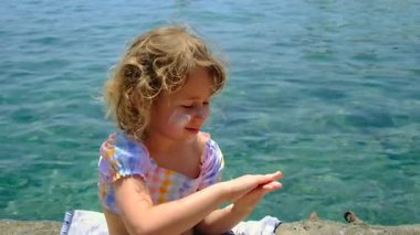 Çocuğun ellerinde güneş kremi var. Seçici odaklanma. çocuk.