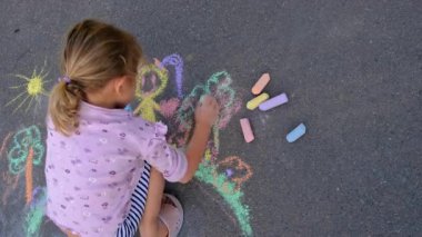 Çocuklar asfalta tebeşirle resim çiziyor. Seçici odaklanma. Çocuk.