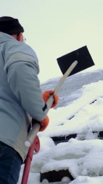 Güneş panellerinden kar temizleyen bir adam. Seçici odaklanma. Doğa.