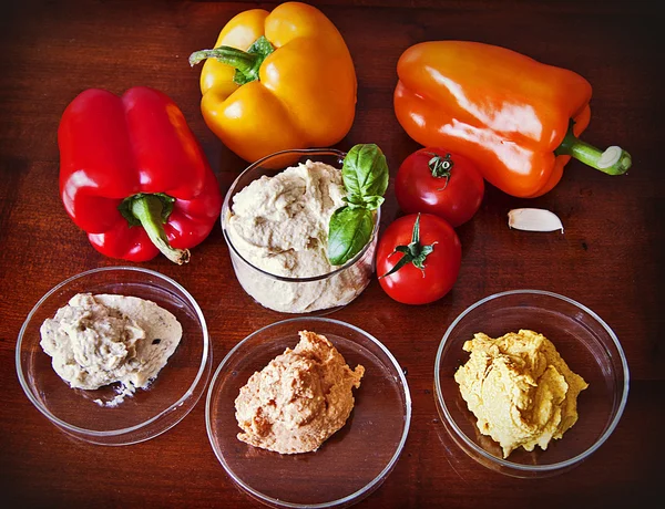 Hummus mit roten, gelben und orangefarbenen Paprika zum Dippen — Stockfoto