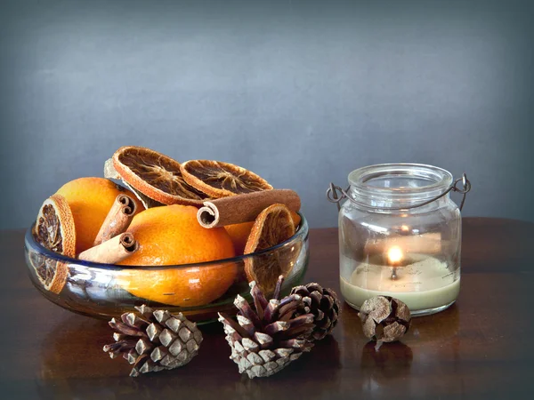 Simple Christmas: bowl with spices and fruits and a candle — Stock Photo, Image