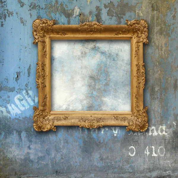 Gold baroque frame on a grunge wall — Stock Photo, Image