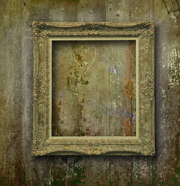 Golden frame on grunge wood wall — Stock Photo, Image