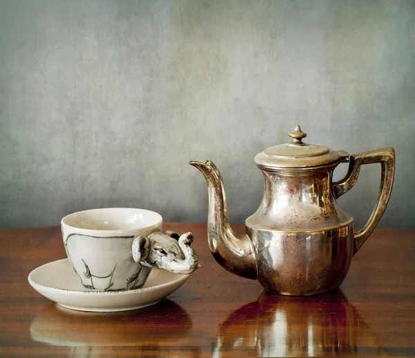 Uma xícara de café e uma cafeteira em uma mesa de madeira — Fotografia de Stock