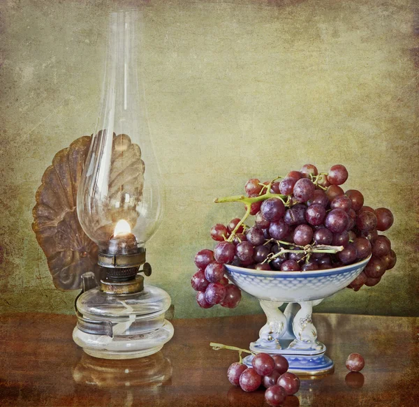 Vintage oil lamp and grapes — Stock Photo, Image