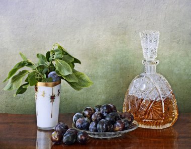 Slivovitz crystal bottle and plums clipart