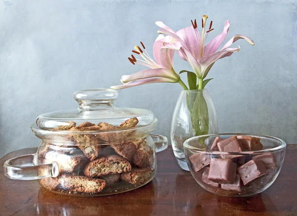 Cookies, chocolates and flowers on a wooden table