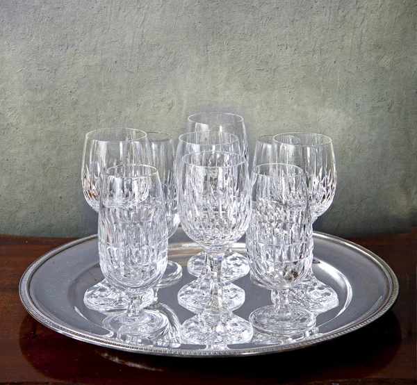 Grunge arka plan üzerinde kristal gözlüklü gümüş tepsi