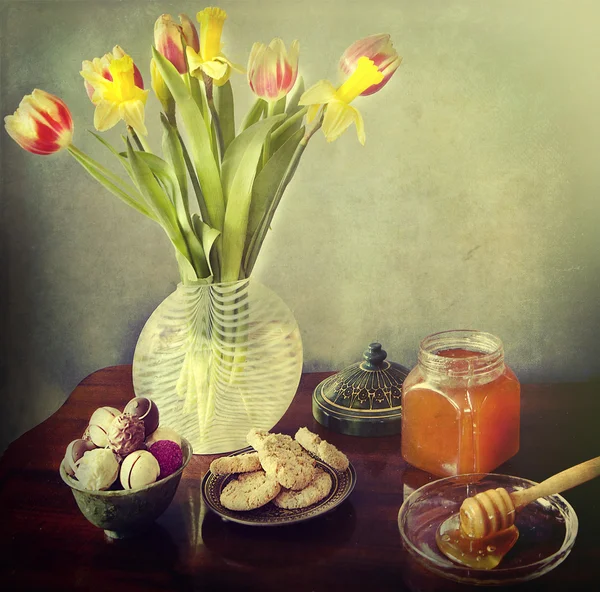 Cukroví, pralinky, med a vázu s tulipány — Stock fotografie