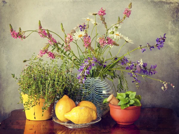 Wildblumen in Vase, Kräuter und Zitronenfrüchte — Stockfoto