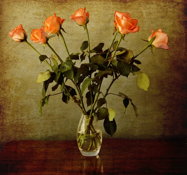 Rosas anaranjadas en un jarrón sobre un fondo grunge vintage —  Fotos de Stock