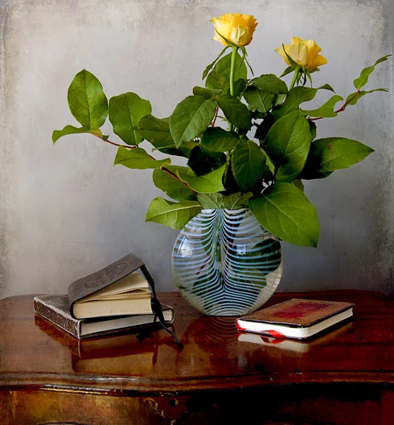 Florero flores y libros viejos en una mesa — Foto de Stock