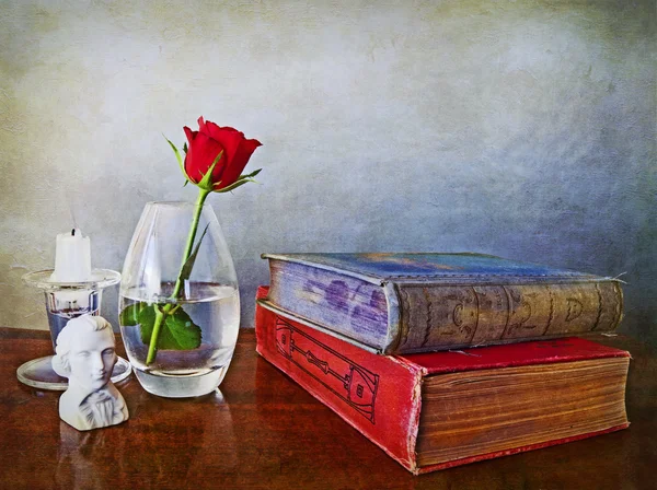 Libros de antigüedades, rosa roja única y otras parafernalia — Foto de Stock