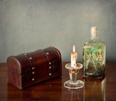 İç Natürmort: ahşap göğüs, mum, cam şişe