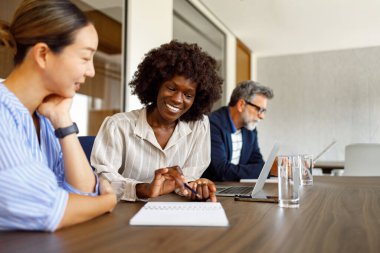 Finans evrakları üzerinde çalışan kadın muhasebeciler şirket ofisindeki belgeleri gözden geçirirken,