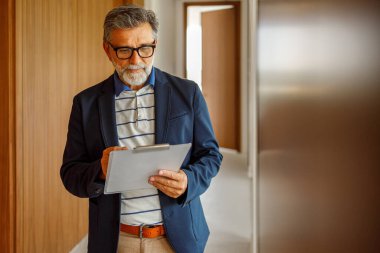 Modern ofiste beyin fırtınası yaparken panoya yazı yazan gözlüklü profesyonel bir erkeğin portresi