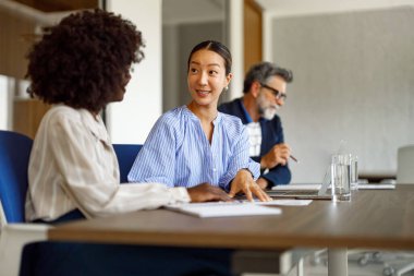 Modern ofiste stratejik planlama toplantısında iş bütçesini tartışan kadın muhasebeciler