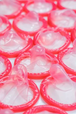 Beyaz arka planda pembe prezervatiflerin yakın çekimi. Güvenli seks kavramı. Hamileliğin azaltılması ve cinsel yolla bulaşan hastalıklar.