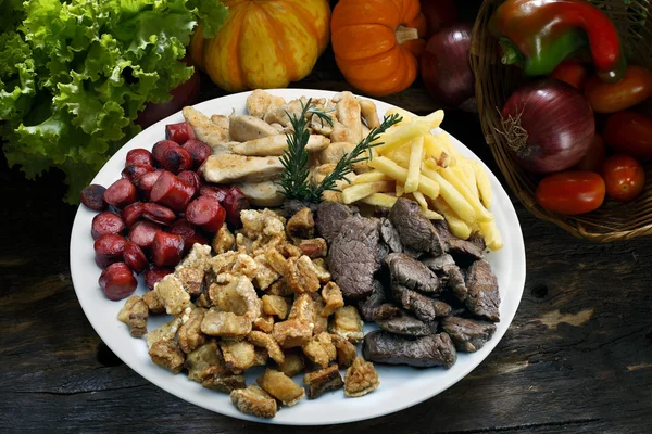 Plate of snacks, meat, potatoes, sausage, cracklings — Stock Photo, Image