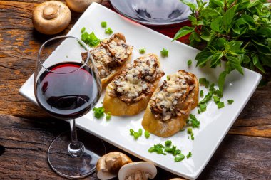 Mantar bruschetta ve rendelenmiş parmesan ve kırmızı şarap.