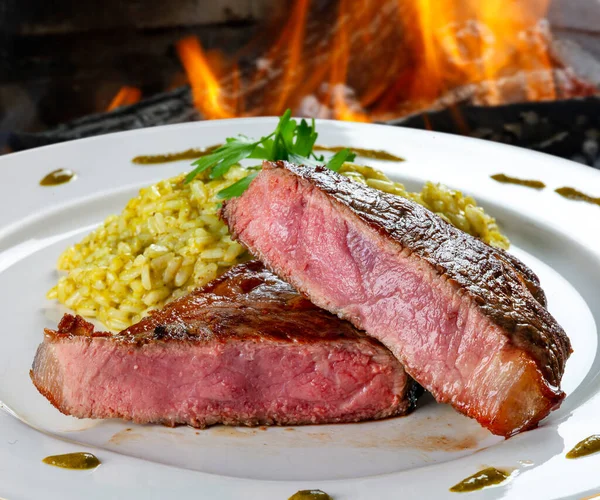 sliced grilled steak served to the point with risotto