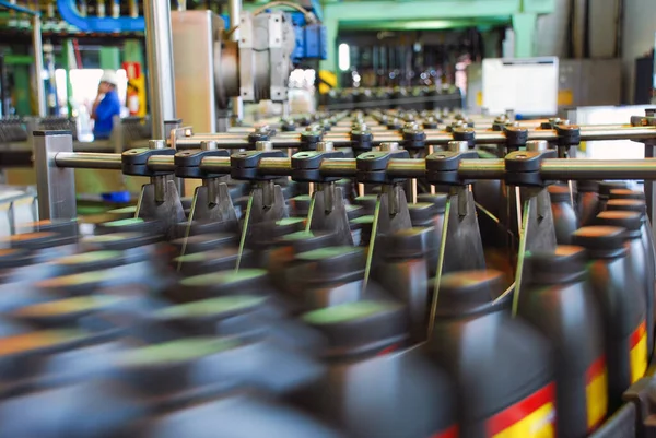 ボトルはコンベアベルトシステム上で搬送されます 自動車潤滑油工場のための産業機械 産業技術の概念 — ストック写真