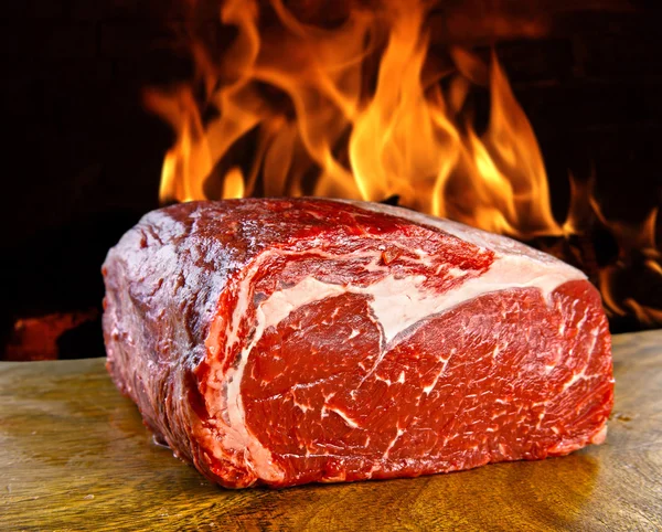 Fresh meat table with fire on background — Stock Photo, Image