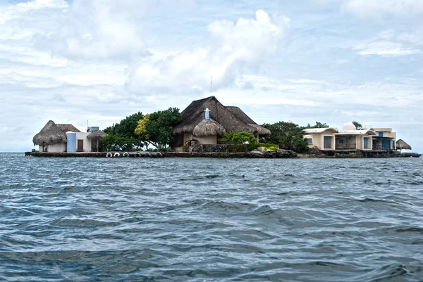 Bungalows on green island in ocean — ストック写真