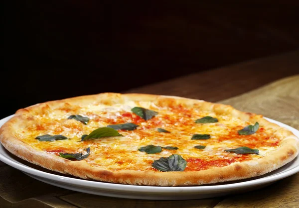 Appetizing, fresh pizza on plate — Stock fotografie