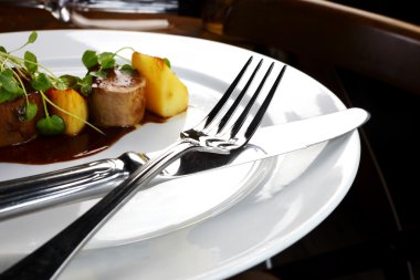 Potatoes and sausage on white plate