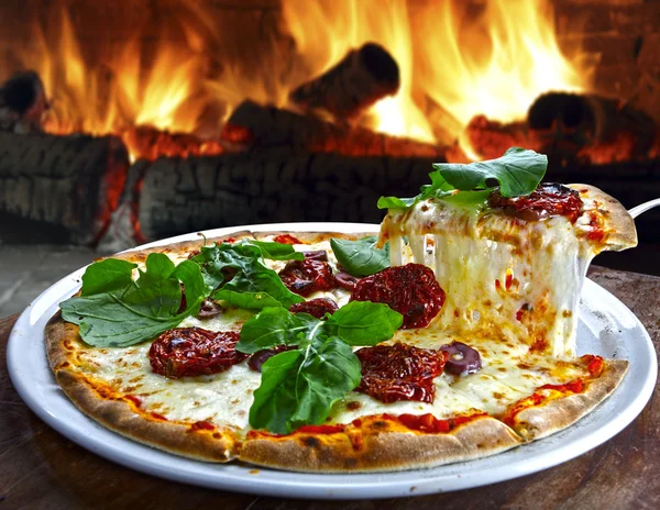 Pizza en un plato con horno de pizza — Foto de Stock