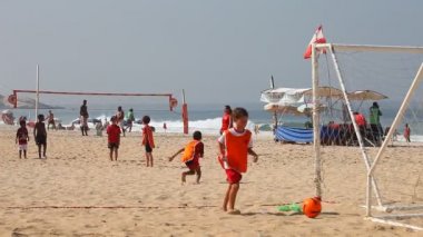 Kumsalda futbol oynayan çocuklar