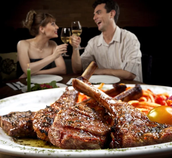 Pareja con costillas asadas delante de ellos — Foto de Stock