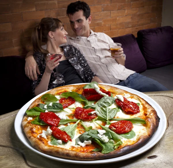 Casal beber coquetel e comer pizza — Fotografia de Stock