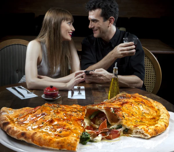 Pareja bebiendo cóctel y comiendo pizza — Foto de Stock