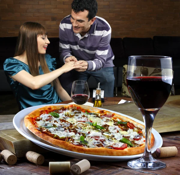 Paar drinken van wijn en eten van pizza — Stockfoto