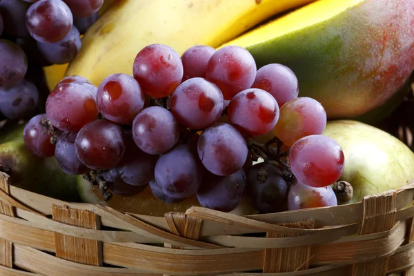 Košík s ovocem na farmě s hroznů, mango, banán. — Stock fotografie