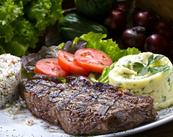 BBQ steak served with salad and potatoes — Stock Photo, Image