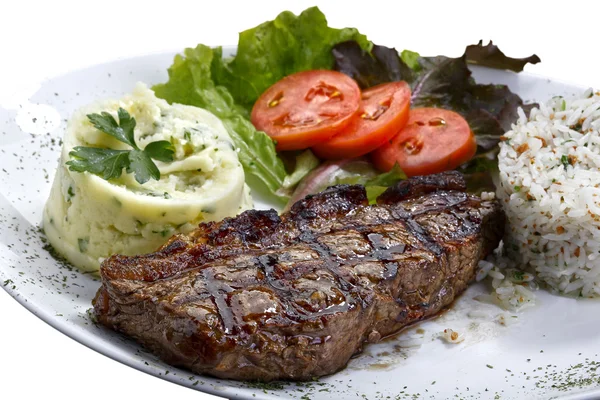 Bife de vaca com batatas e arroz em fundo branco isolado — Fotografia de Stock