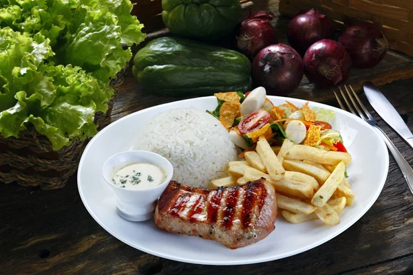 Grilled pork with fries and vegetables — Stock Photo, Image