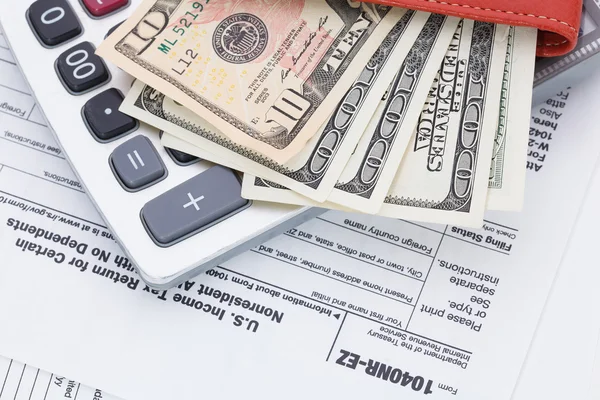 Money and calculator on tax form background — Stock Photo, Image