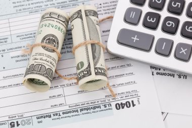 Vergi formu arka plan üzerinde bir ip ile bağlı dolar faturaları