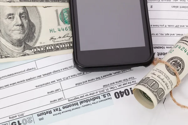 Peníze a mobil na pozadí formuláře daňových — Stock fotografie