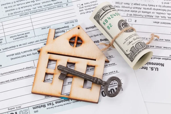 Money and wooden house with vintage key on tax form background — Stock Photo, Image