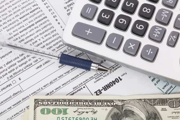 Peníze a kalkulačku na pozadí formuláře daňových — Stock fotografie