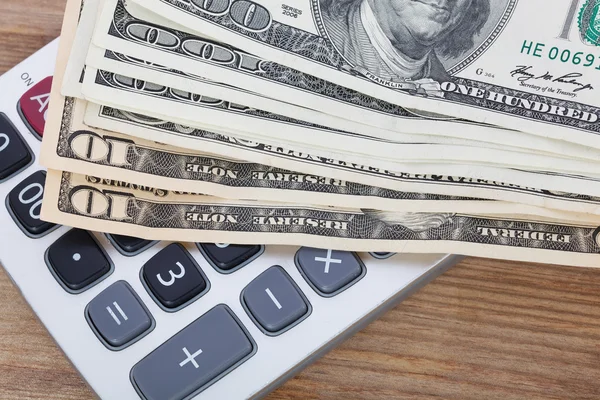 Money and calculator on wooden table background — Stock Photo, Image