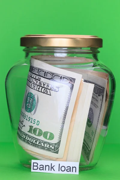 Money in glass jars, on Green background with sign - Bank loan — Stock Photo, Image